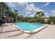 Exterior view of the lovely pool with a brick paved deck, with palm trees, an American flag, and the pool house at 532 Oak Hill Cir # 12, Sarasota, FL 34232