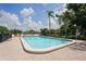 Inviting outdoor pool with clear water surrounded by a brick patio, lush trees, and community homes at 532 Oak Hill Cir # 12, Sarasota, FL 34232