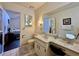 Bathroom features vanity, toilet, large mirror, patterned walls, and view to the bedroom at 5400 34Th W St # H12, Bradenton, FL 34210