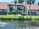 Exterior view of this two-story home with balcony and lush landscaping on a pond at 5400 34Th W St # H12, Bradenton, FL 34210