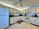 A kitchen featuring tiled floors, white appliances, and white cabinets at 5400 34Th W St # H12, Bradenton, FL 34210