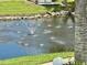 Scenic water feature in a community pond with lush green grass and a palm tree at 5400 34Th W St # H12, Bradenton, FL 34210