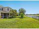 Expansive backyard featuring lush green grass, mature trees, and a serene lake view at 5709 Wild Sage Cir, Sarasota, FL 34238
