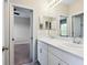 Bright bathroom featuring dual sinks, white cabinetry and a view into an adjacent room at 5709 Wild Sage Cir, Sarasota, FL 34238