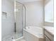 Bright bathroom featuring a glass shower with tiled walls, pebble floor, and a soaking tub at 5709 Wild Sage Cir, Sarasota, FL 34238