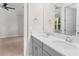Bathroom vanity featuring double sinks with chrome faucets and a view into a bedroom at 5709 Wild Sage Cir, Sarasota, FL 34238