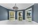 Bright dining area featuring three windows, blue walls, white trim and a decorative chandelier at 5709 Wild Sage Cir, Sarasota, FL 34238