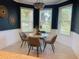 Eat-in kitchen area with a modern round table, four chairs, and abundant natural light from three windows at 5709 Wild Sage Cir, Sarasota, FL 34238
