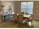 Inviting dining room with hardwood floors, stylish furniture, and ample natural light from the window at 5709 Wild Sage Cir, Sarasota, FL 34238
