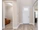 Bright entryway featuring wood-look floors, a white door, and an alcove with built-in bench seating at 5709 Wild Sage Cir, Sarasota, FL 34238
