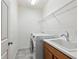 Functional laundry room with a utility sink, laundry machines and metal shelving at 5709 Wild Sage Cir, Sarasota, FL 34238