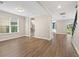 Open-concept living room with hardwood floors and neutral walls leading into the kitchen and sunroom at 5709 Wild Sage Cir, Sarasota, FL 34238