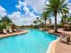 Resort-style pool area with lounge chairs, umbrellas, and lush tropical landscaping at 5709 Wild Sage Cir, Sarasota, FL 34238