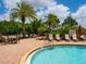 Refreshing community pool with poolside seating surrounded by lush greenery and palm trees at 5709 Wild Sage Cir, Sarasota, FL 34238