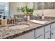 Granite countertop vanity in bathroom featuring dual sinks, decorative plant, and plenty of counter space at 5843 Wake Forest Run # 104, Bradenton, FL 34211