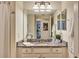 Bathroom featuring a mirror, shower, and granite countertops, combining elegance with practical design at 5843 Wake Forest Run # 104, Bradenton, FL 34211