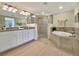 Spacious bathroom features a double vanity, soaking tub, and a glass-enclosed shower at 5843 Wake Forest Run # 104, Bradenton, FL 34211