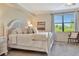 Bright bedroom featuring a white-painted wooden bed frame, neutral bedding, and a large window with blinds at 5843 Wake Forest Run # 104, Bradenton, FL 34211