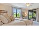 Comfortable bedroom with slider to the patio, featuring a plush bed, dresser, and natural light at 5843 Wake Forest Run # 104, Bradenton, FL 34211