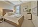 Bedroom featuring a tropical painting, woven bed frame, and a ceiling fan, radiating relaxation and style at 5843 Wake Forest Run # 104, Bradenton, FL 34211