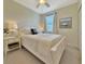 Comfortable bedroom with a boat painting, a ceiling fan, a window, and white furniture at 5843 Wake Forest Run # 104, Bradenton, FL 34211