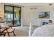 Bedroom with a slider to screened patio, featuring white furnishings and a television at 5843 Wake Forest Run # 104, Bradenton, FL 34211