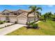 Paired villas with two-car garages, stone accents, mature landscaping, and brick-paver driveways and walkways at 5843 Wake Forest Run # 104, Bradenton, FL 34211