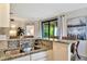 Modern kitchen area with granite countertops, stainless steel sink, and an open view to the bedroom at 5843 Wake Forest Run # 104, Bradenton, FL 34211