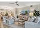 Comfortable living room with ample seating, a ceiling fan, decorative lamps, and a stylish media console at 5843 Wake Forest Run # 104, Bradenton, FL 34211