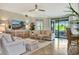 Inviting living room with comfortable seating, large TV, a ceiling fan, and sliding glass doors to the lanai at 5843 Wake Forest Run # 104, Bradenton, FL 34211