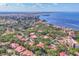 Expansive aerial view of the residential area, showing red tile roofs, lush trees, and community pool near the water at 6501 Mourning Dove Dr # 215, Bradenton, FL 34210