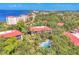 Aerial view featuring mature trees and a condo complex, with a glimpse of the ocean in the background at 6501 Mourning Dove Dr # 215, Bradenton, FL 34210