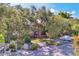 Exterior view of the condo building, showcasing lush trees, landscaping, and parking at 6501 Mourning Dove Dr # 215, Bradenton, FL 34210