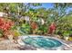 A quaint hot tub is surrounded by tropical landscaping and a privacy fence at 6501 Mourning Dove Dr # 215, Bradenton, FL 34210