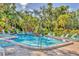 A community pool is surrounded by mature tropical landscaping and comfortable lounge seating at 6501 Mourning Dove Dr # 215, Bradenton, FL 34210