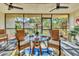 Enclosed porch featuring an outdoor dining set and views of lush greenery at 6501 Mourning Dove Dr # 215, Bradenton, FL 34210