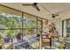 Bright sunroom features a glass table, comfortable seating, and views of lush tropical greenery beyond the screened windows at 6501 Mourning Dove Dr # 215, Bradenton, FL 34210