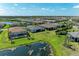 Aerial view of neighborhood with many screened pools backing to a large pond at 7136 Summerland Cv, Bradenton, FL 34202