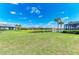 Spacious backyard with a pond view and lush green grass on a sunny day at 7136 Summerland Cv, Bradenton, FL 34202