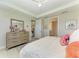 Bright bedroom with a ceiling fan, dresser, and a glimpse into other rooms at 7136 Summerland Cv, Bradenton, FL 34202