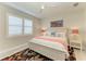 Bedroom with white furnishings, plantation shutters, and decorative wall art at 7136 Summerland Cv, Bradenton, FL 34202