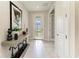 Bright foyer with stylish console table and decor, tiled flooring, and a view of the front door at 7136 Summerland Cv, Bradenton, FL 34202