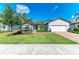 Beautiful single-story home featuring a well-manicured lawn, mature trees, and a two-car garage at 7136 Summerland Cv, Bradenton, FL 34202