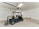 Spacious garage with a blue golf cart parked inside; room for vehicles and storage at 7136 Summerland Cv, Bradenton, FL 34202