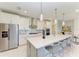 Modern kitchen featuring stainless steel appliances, a large island with seating, and stylish finishes at 7136 Summerland Cv, Bradenton, FL 34202