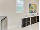 Bright laundry room with decorative elements and a storage unit with multiple cubbies at 7136 Summerland Cv, Bradenton, FL 34202