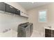 Well-lit laundry room with gray washer and dryer, ample shelving, and a sink at 7136 Summerland Cv, Bradenton, FL 34202