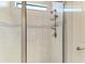 Close-up of a tiled shower with glass doors and multiple shower heads at 7136 Summerland Cv, Bradenton, FL 34202
