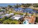 Aerial view shows a waterfront home with a screened lanai, a pool and a scenic view of the water and boat docks at 7817 Alhambra Dr, Bradenton, FL 34209