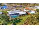 Aerial view shows a waterfront home with a screened lanai and pool and a scenic view of the canal at 7817 Alhambra Dr, Bradenton, FL 34209